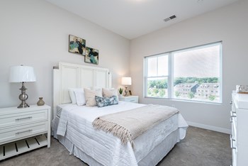 Millside bedroom with large open windows and plush carpet
